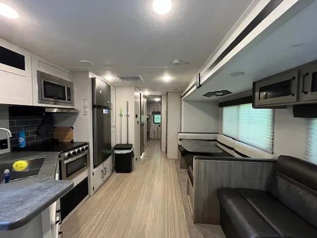 a kitchen with stainless steel appliances granite countertop a refrigerator a stove and a sink