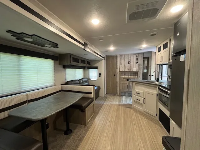 a kitchen with refrigerator and chairs
