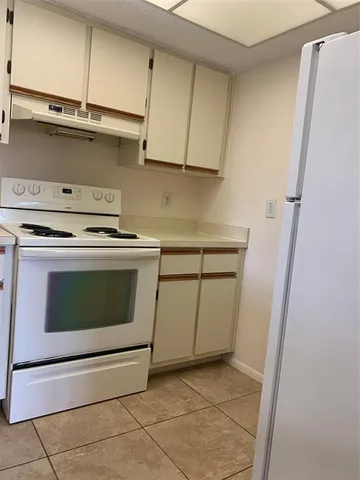 a kitchen with a stove top oven and cabinets