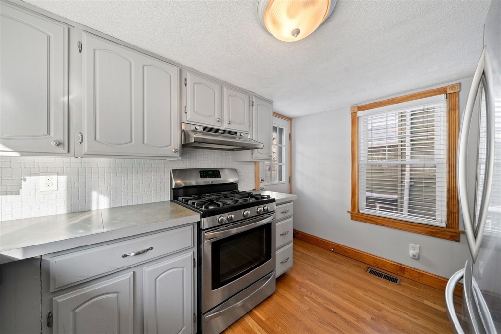 86-88 Pearl Street Boston, MA 02129 - Photo 13 of 30 a kitchen with granite countertop a stove a sink and dishwasher wooden cabinets with granite countertops