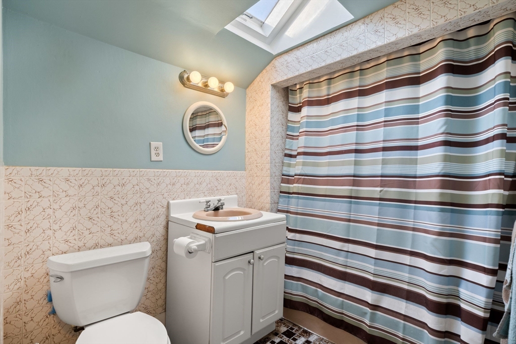 86-88 Pearl Street Boston, MA 02129 - Photo 28 of 30 a bathroom with a sink a toilet and a shower curtain