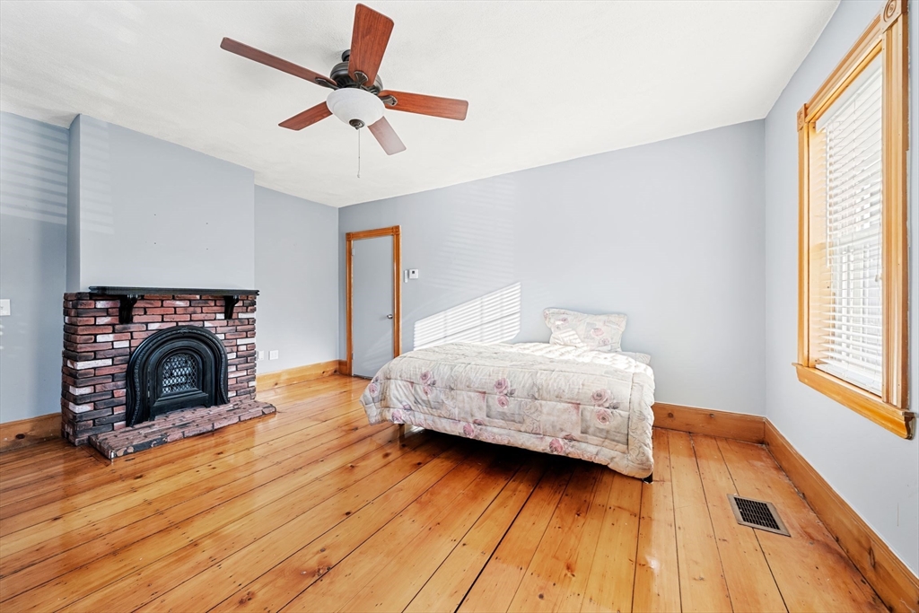 86-88 Pearl Street Boston, MA 02129 - Photo 10 of 30 a bedroom with a bed and a fireplace