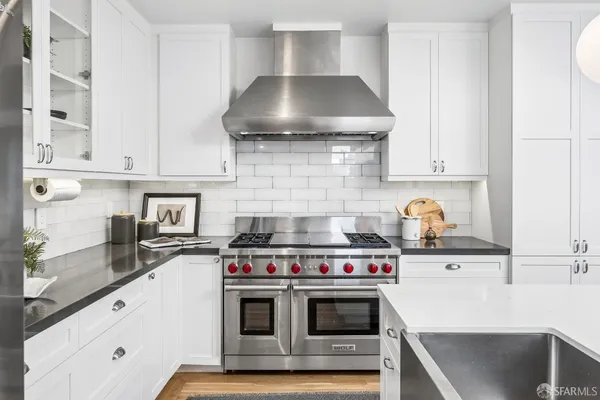 a kitchen with stainless steel appliances a stove and a cabinets