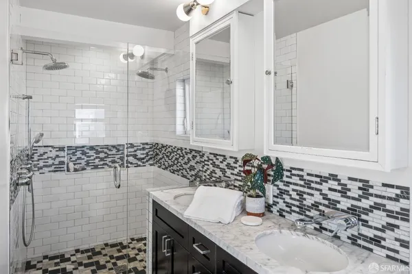 a bathroom with a granite countertop sink a toilet and shower