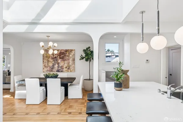 a dining room with chandelier and wooden floor