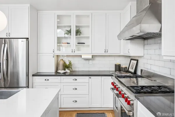 a kitchen with white cabinets and appliances