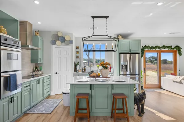 a kitchen with stainless steel appliances granite countertop a sink and a refrigerator