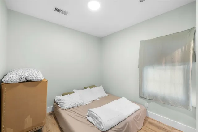 a bed sitting in a bedroom next to a bathroom