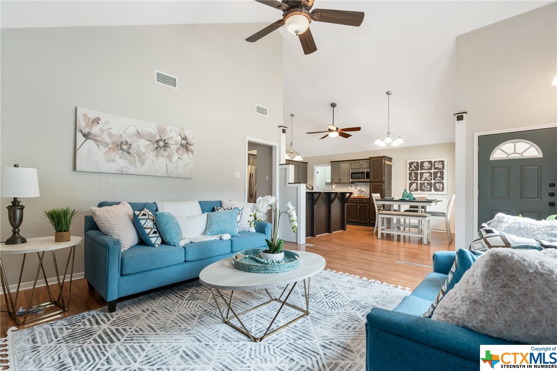 a living room with furniture kitchen view and a large window