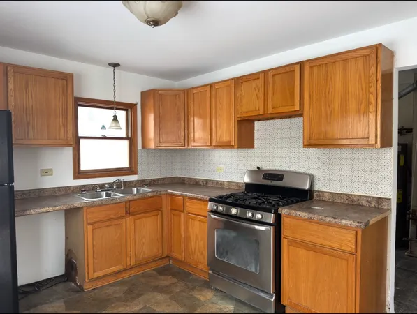 a kitchen with stainless steel appliances granite countertop a stove a sink and a microwave