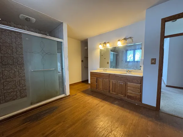 a bathroom with a double vanity sink a toilet and a shower