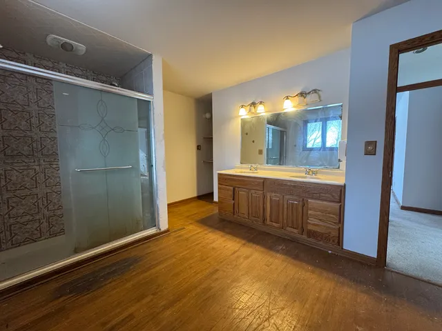 a bathroom with a double vanity sink a toilet and a shower