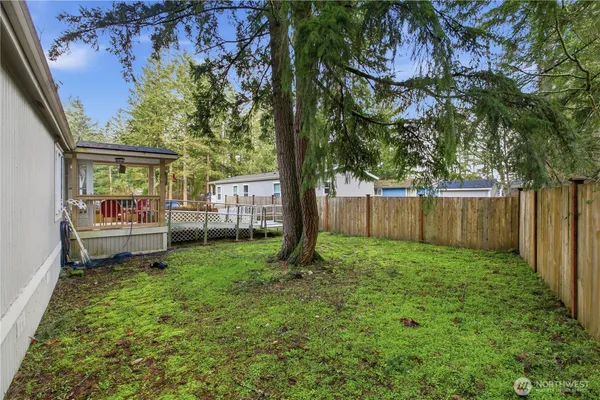 a view of a backyard with wooden fence and a bench