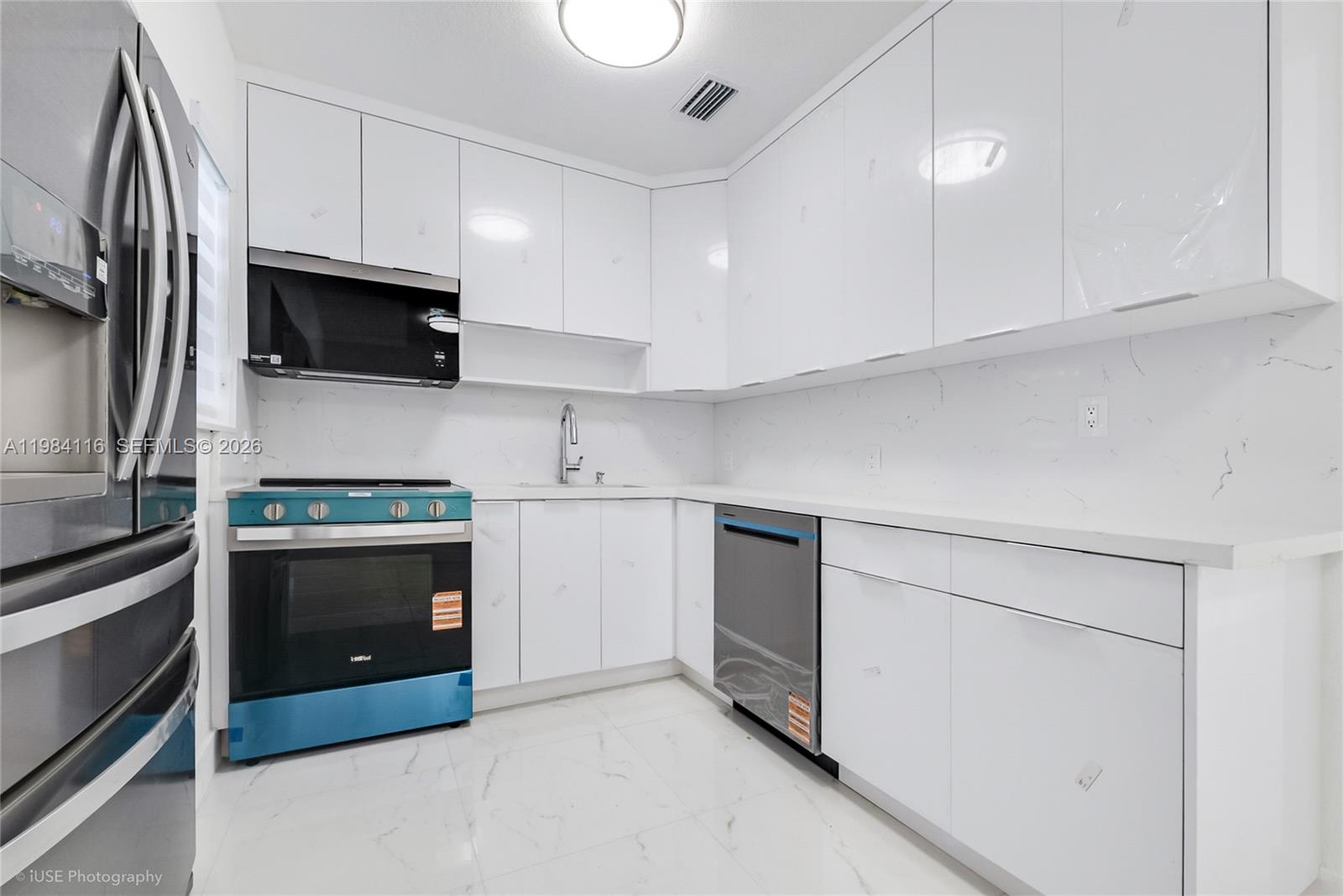 6337 Southwest 11th Street West Miami, FL 33144 - Photo 12 of 28 a kitchen with stainless steel appliances a stove sink and microwave
