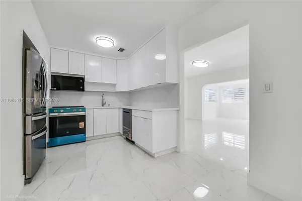 a kitchen with stainless steel appliances a stove top oven a refrigerator and a sink