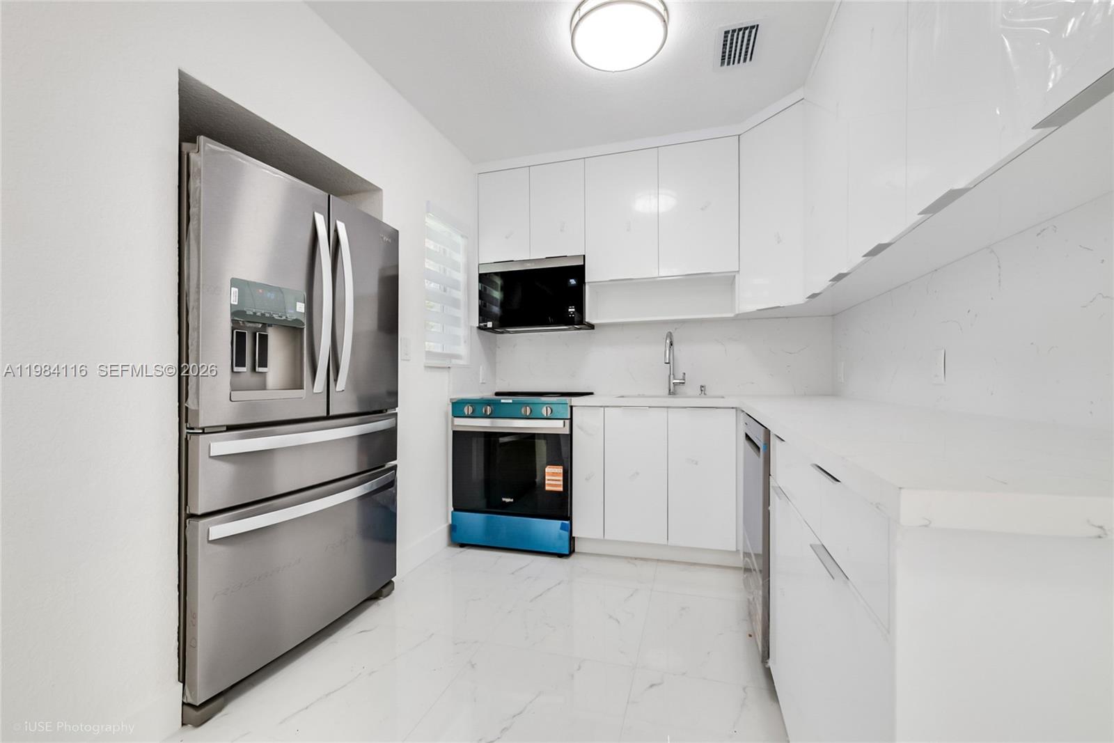 6337 Southwest 11th Street West Miami, FL 33144 - Photo 14 of 28 a kitchen with stainless steel appliances and cabinets