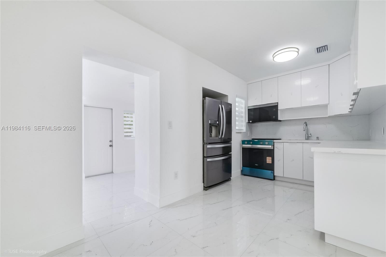 6337 Southwest 11th Street West Miami, FL 33144 - Photo 15 of 28 a kitchen with stainless steel appliances a refrigerator and a stove top oven