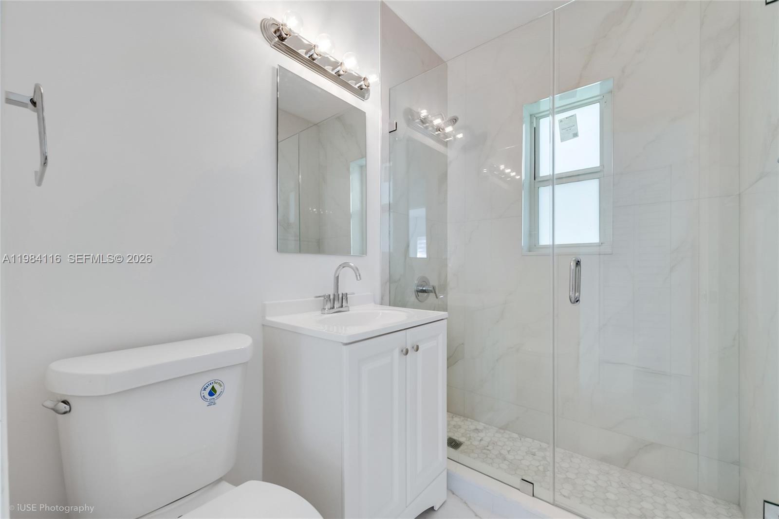 6337 Southwest 11th Street West Miami, FL 33144 - Photo 20 of 28 a bathroom with a toilet a sink a mirror and a shower