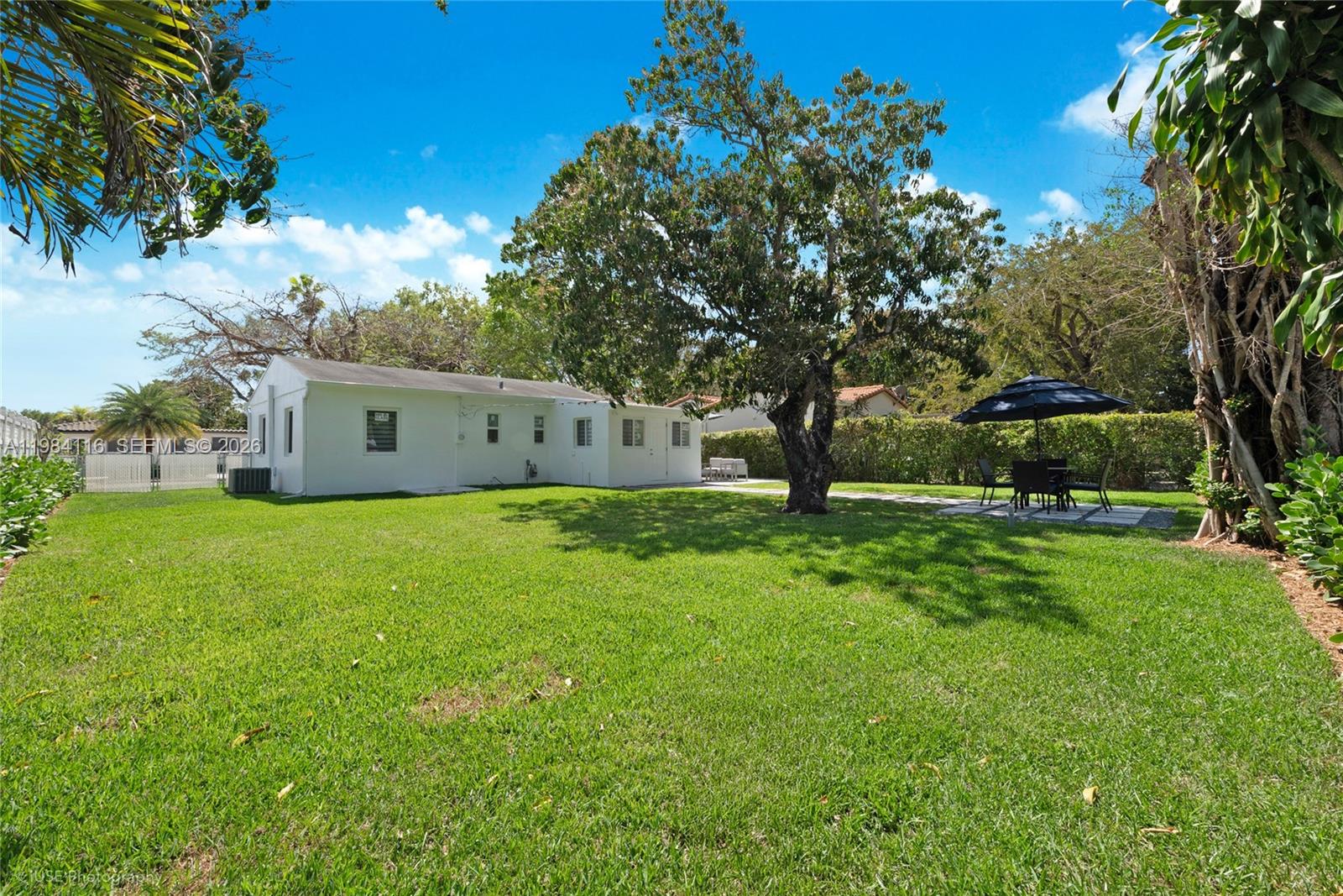 6337 Southwest 11th Street West Miami, FL 33144 - Photo 26 of 28 a white house with a big yard and large trees