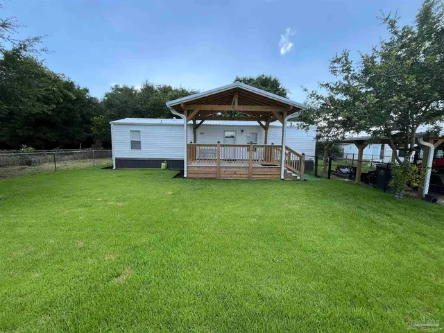 a view of a house with a yard and sitting area