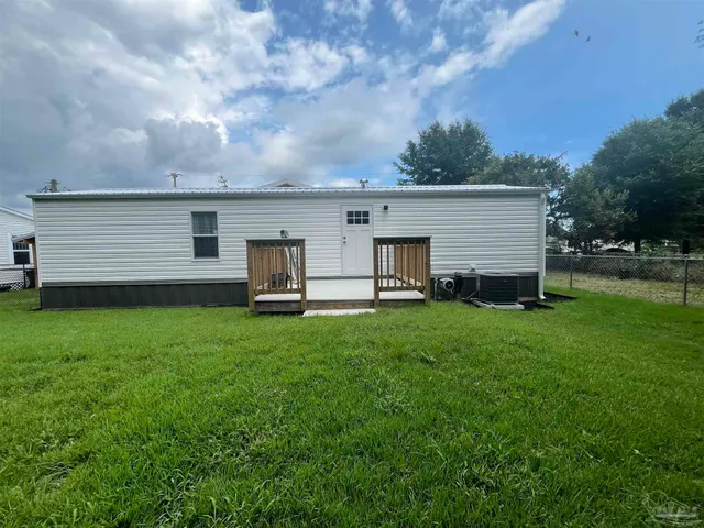 a view of a backyard with brick wall and a large tree