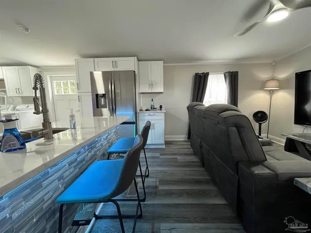 a living room with furniture a lamp wooden floor and a large window