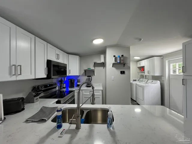 a kitchen that has a lot of cabinets a sink and a stove in it