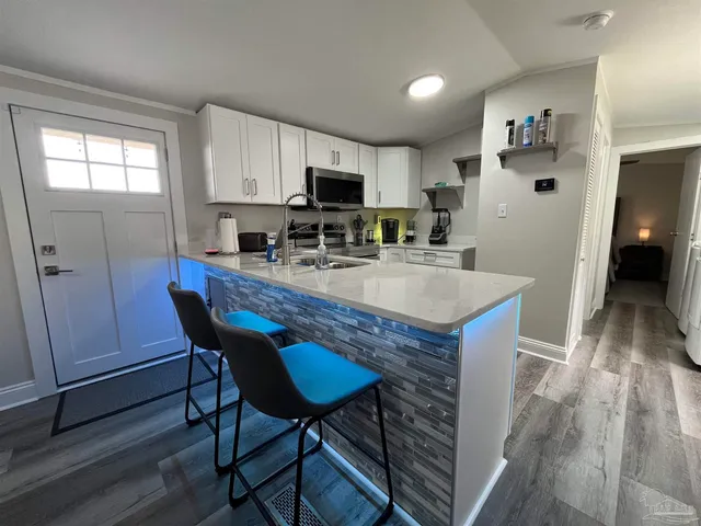 a kitchen with a dining table chairs and refrigerator