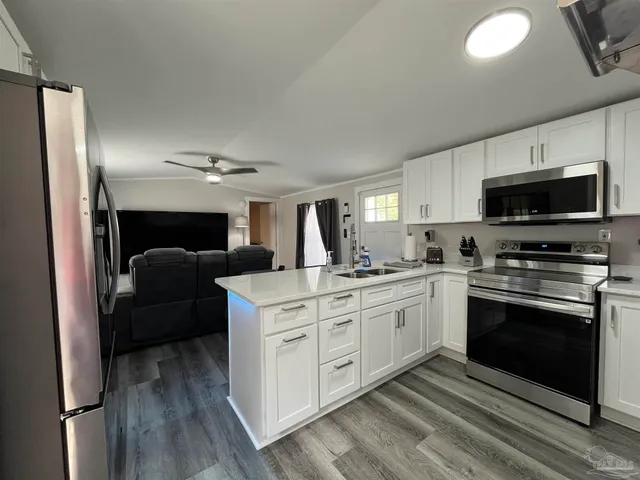 a kitchen with stainless steel appliances granite countertop a stove a sink and a refrigerator