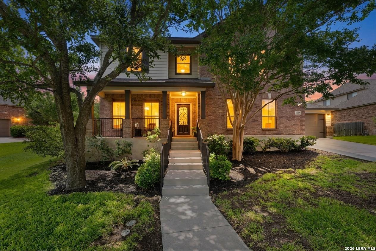 14507 John David Helotes, TX 78023 - Photo 2 of 52 a view of a brick house next to a yard with potted plants and large trees