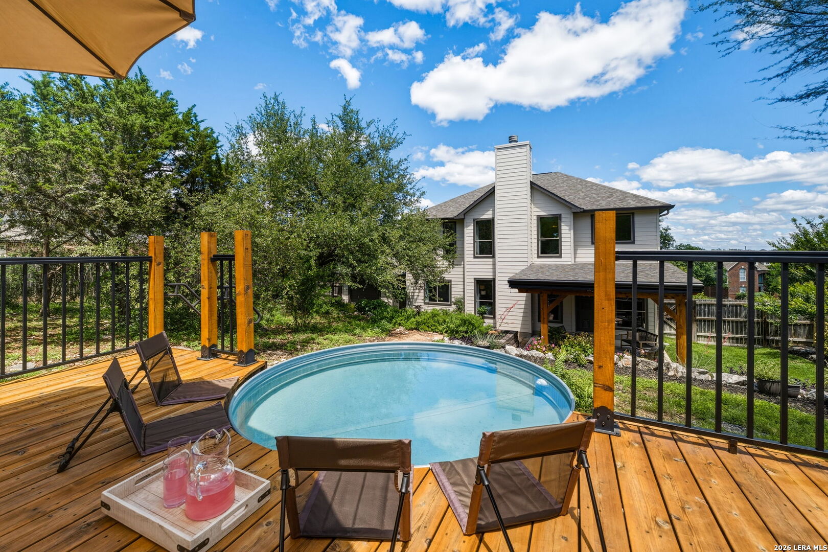 14507 John David Helotes, TX 78023 - Photo 27 of 52 a view of a patio with couches table and chairs under an umbrella with wooden floor