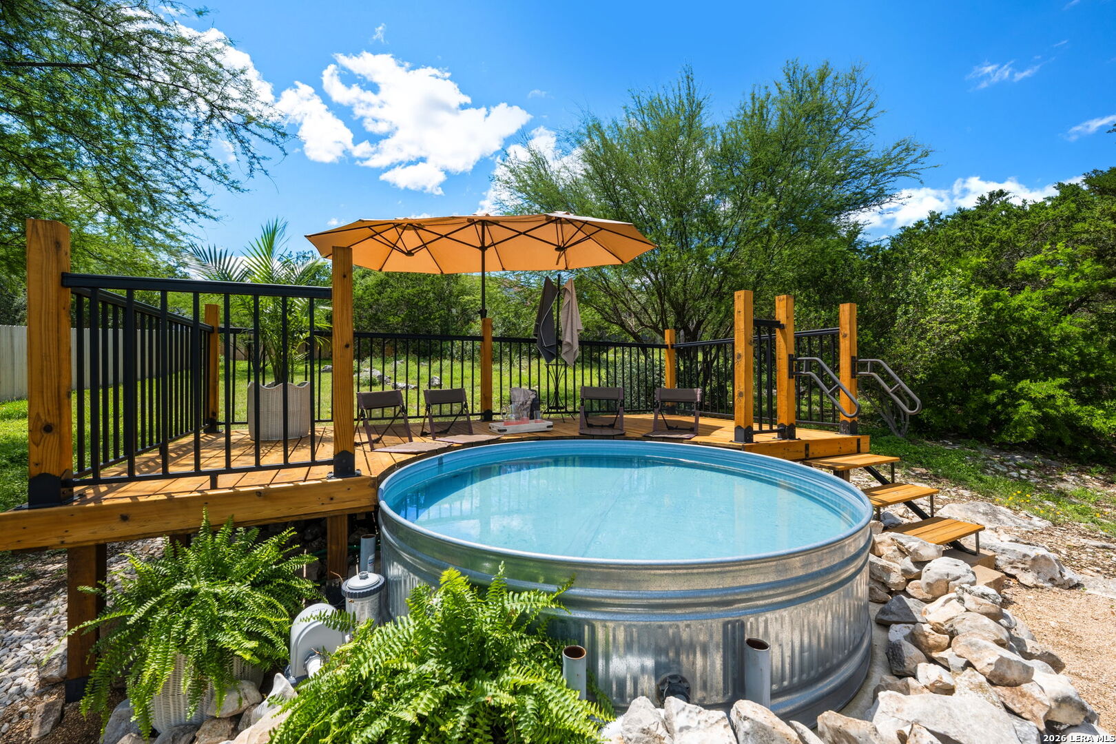 14507 John David Helotes, TX 78023 - Photo 48 of 52 a view of swimming pool with a table and chairs under an umbrella