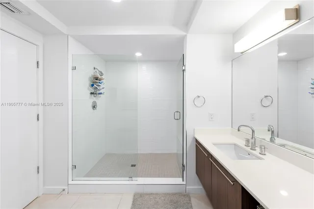 a bathroom with a bath tub sink mirror and shower