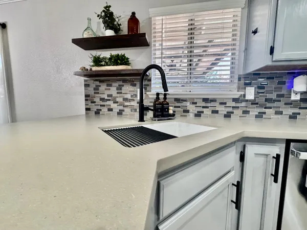 a kitchen with a sink a stove and a window