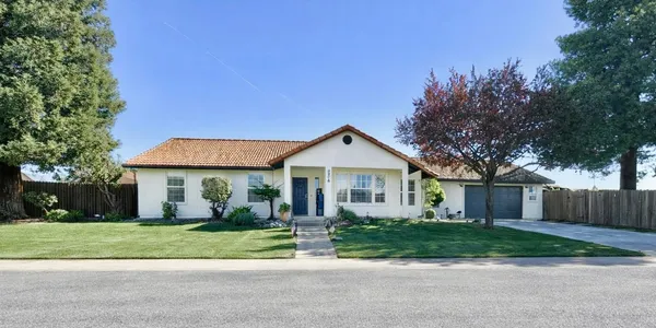 a front view of a house with a yard and potted plants