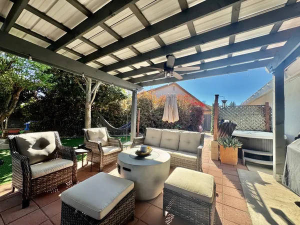 a view of a patio with couches chairs and a table and chairs with garden view