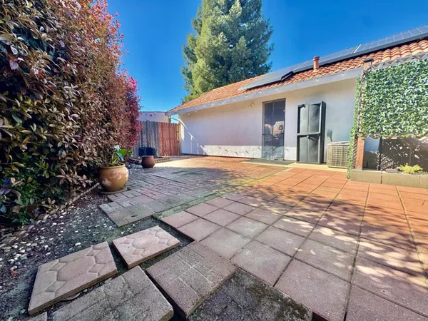 a view of a backyard with a tree and wooden fence