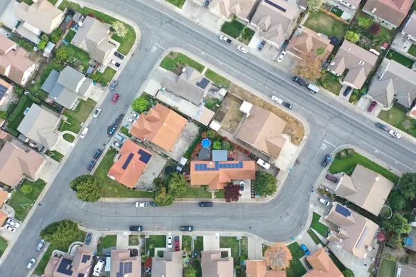 an aerial view of a city with lots of residential buildings and mountain view in back