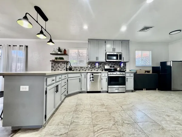 a kitchen with stainless steel appliances granite countertop a stove top oven and cabinets