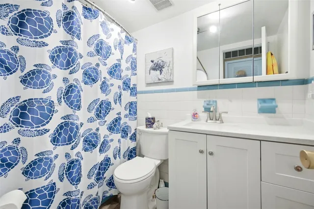 a bathroom with a sink and mirror with toilet