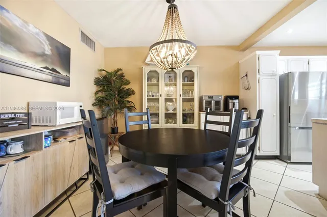 a view of a dining room with furniture a chandelier and wooden floor