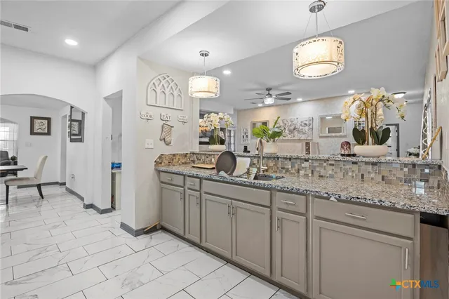 an open kitchen with a sink and dishwasher with kitchen view
