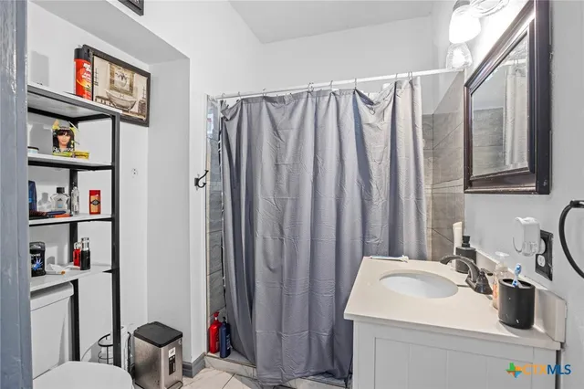 a bathroom with a sink a toilet and a shower curtain