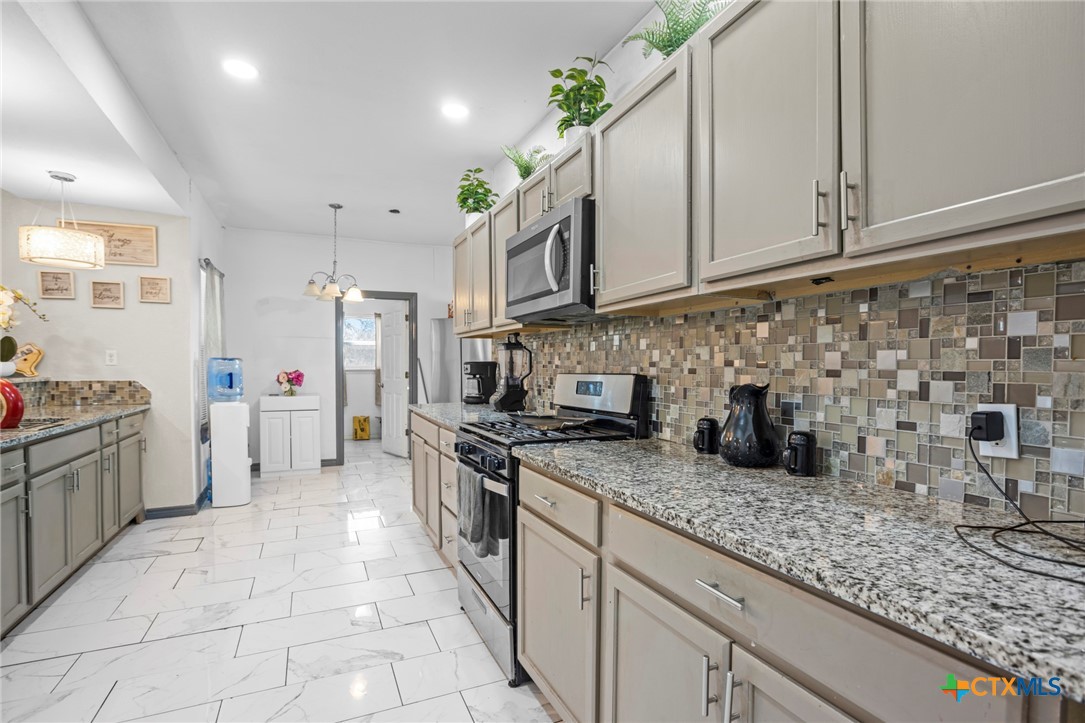 811 Ward Street Marlin, TX 76661 - Photo 10 of 31 a kitchen with stainless steel appliances granite countertop a sink stove and cabinets