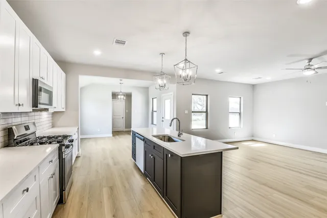 a kitchen with kitchen island a sink stainless steel appliances and cabinets