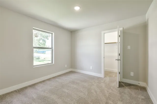 an empty room with windows and closet