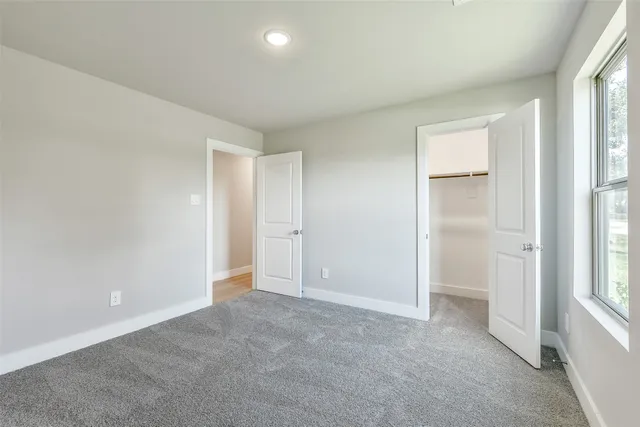 an empty room with windows and closet