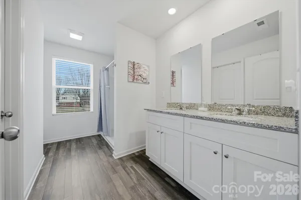 a bathroom with granite countertop a sink and wooden floor