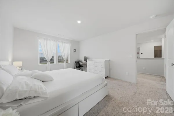 a bedroom with a bed and a large window