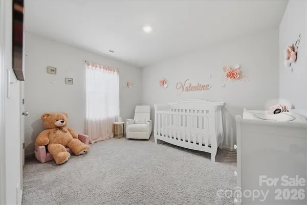a living room with furniture and a baby crib
